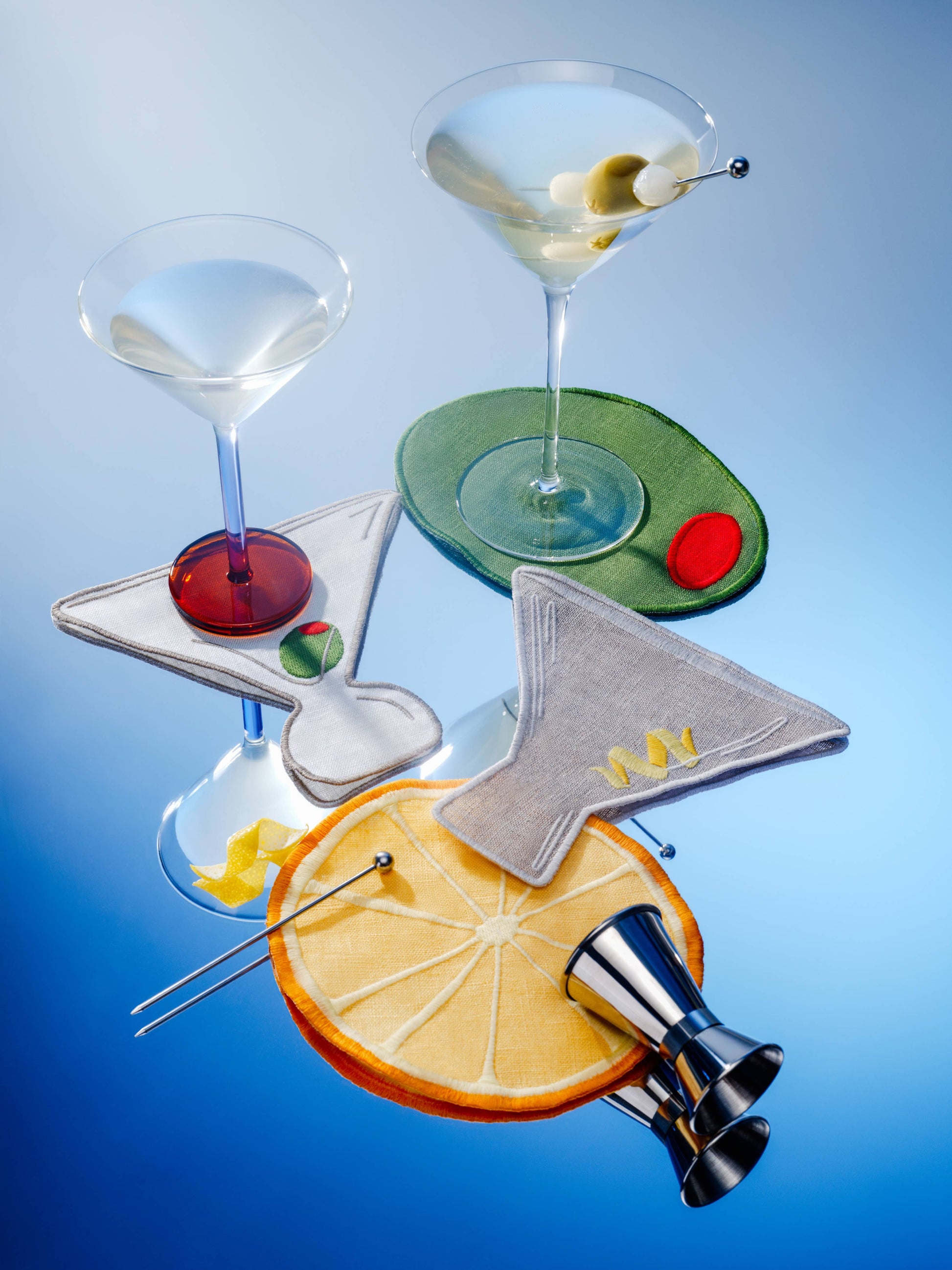 Set of cocktail glasses with garnishes on a blue background
