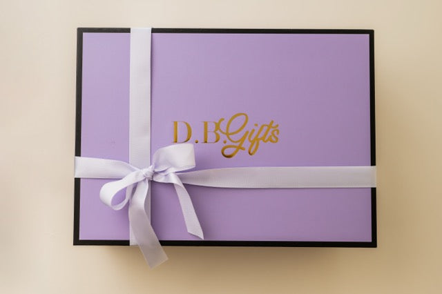 Purple gift box with white ribbon and 'D.B Gifts' text on a beige background