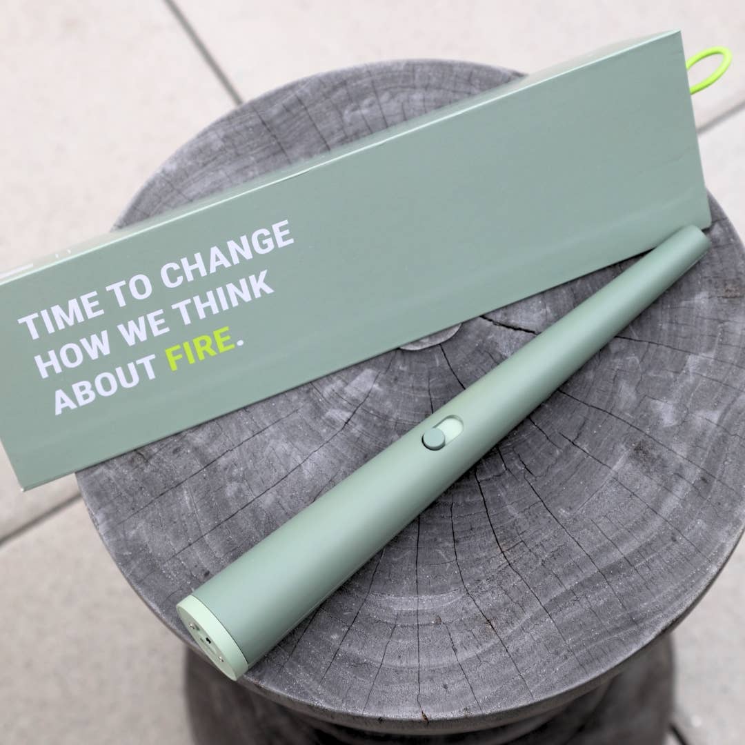 Light green handheld device on a wooden stump with a green box labeled 'Time to change how we think about fire'.