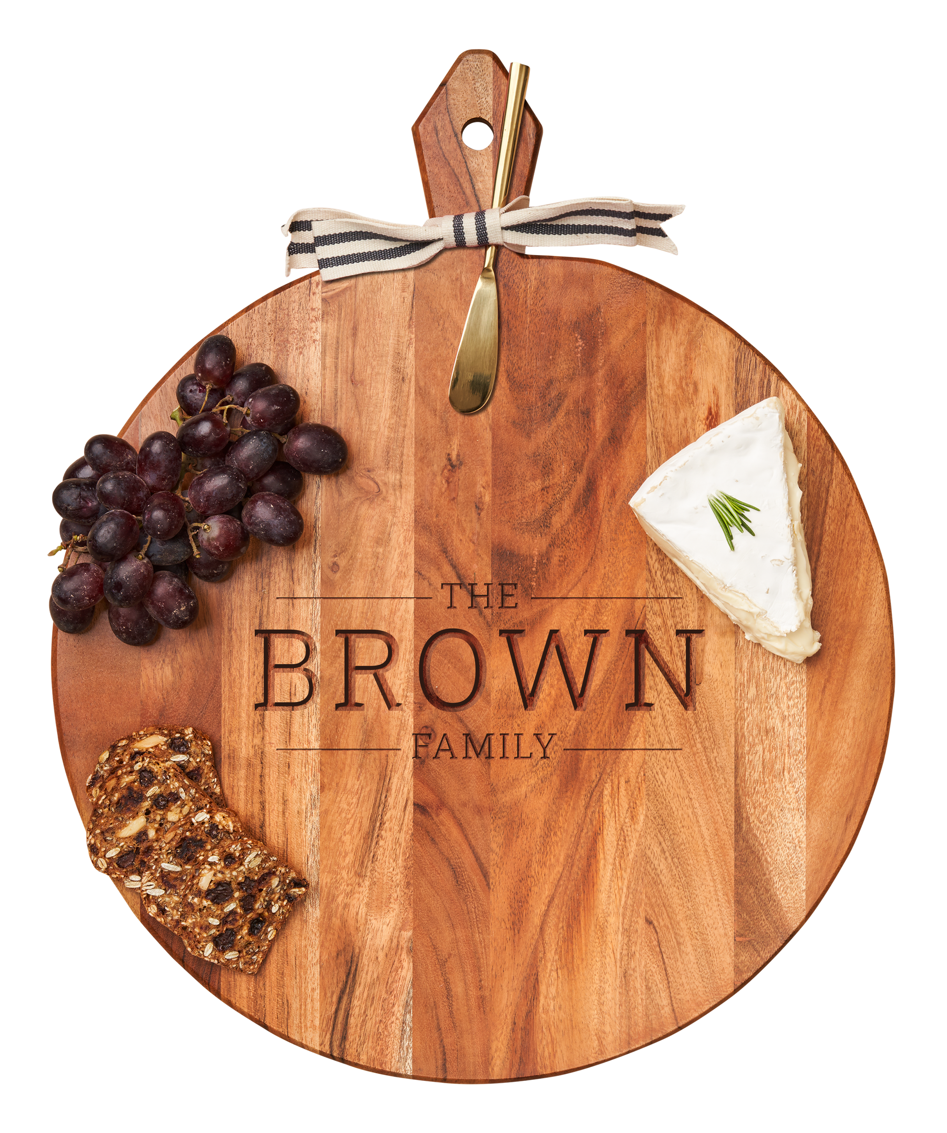 Wooden cutting board with engraved 'The Brown Family' and food items on a white background