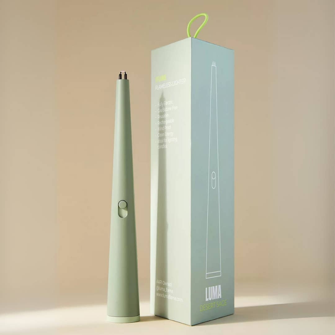 Light green lighter-like device with a matching box on a beige background
