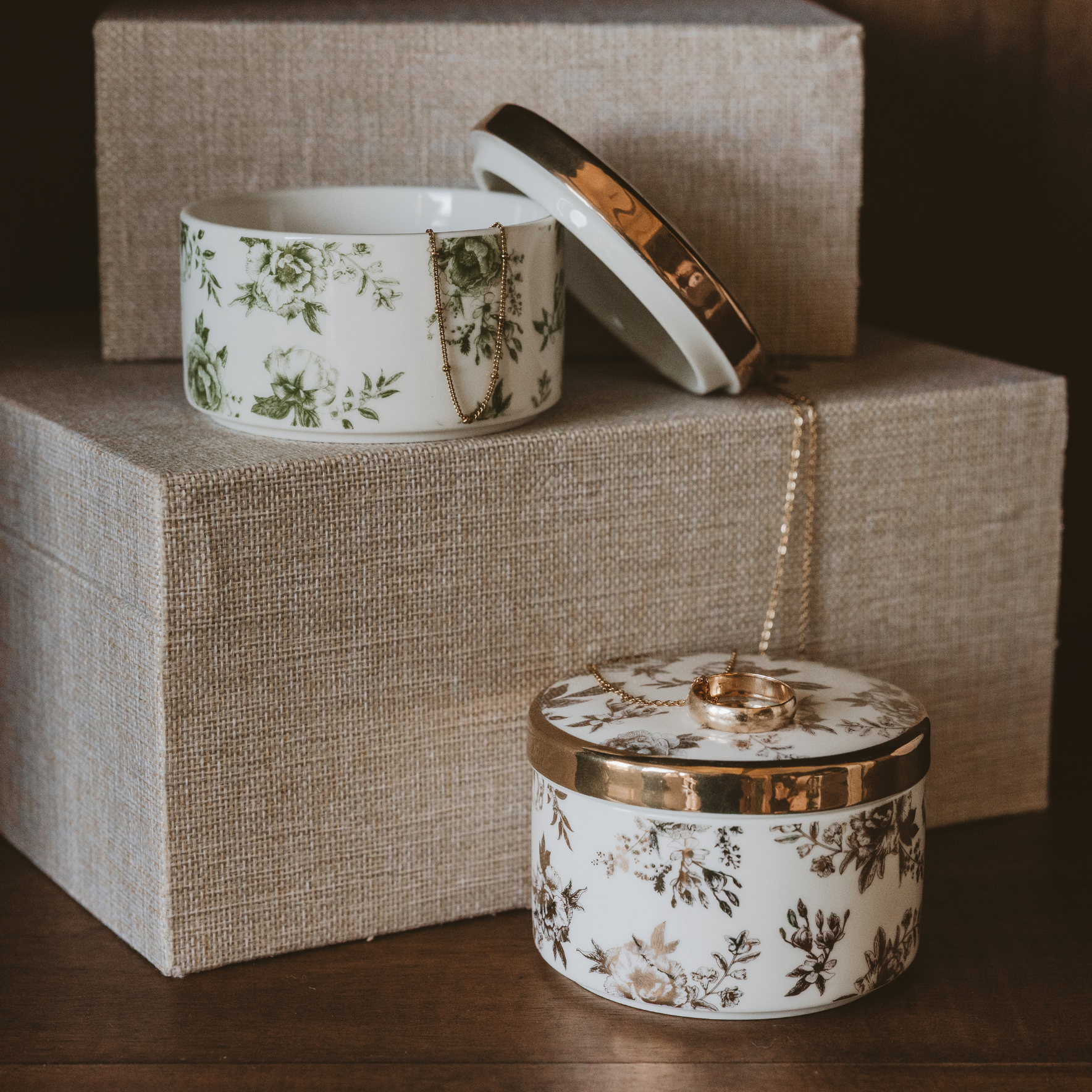 Two ceramic containers with floral patterns on a textured surface