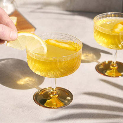 Cocktail glass with lemon slice on a light surface